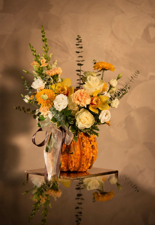 Golden Gratitude pumpkin arrangement with yellow orchids, white roses and peach flowers by The Flower Lab