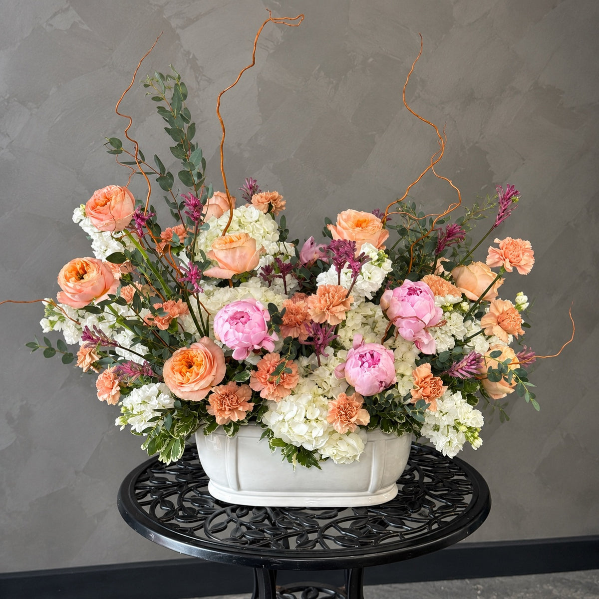 Special Touch corporate flower arrangement with peach roses, pink peonies, white hydrangeas and seasonal flowers